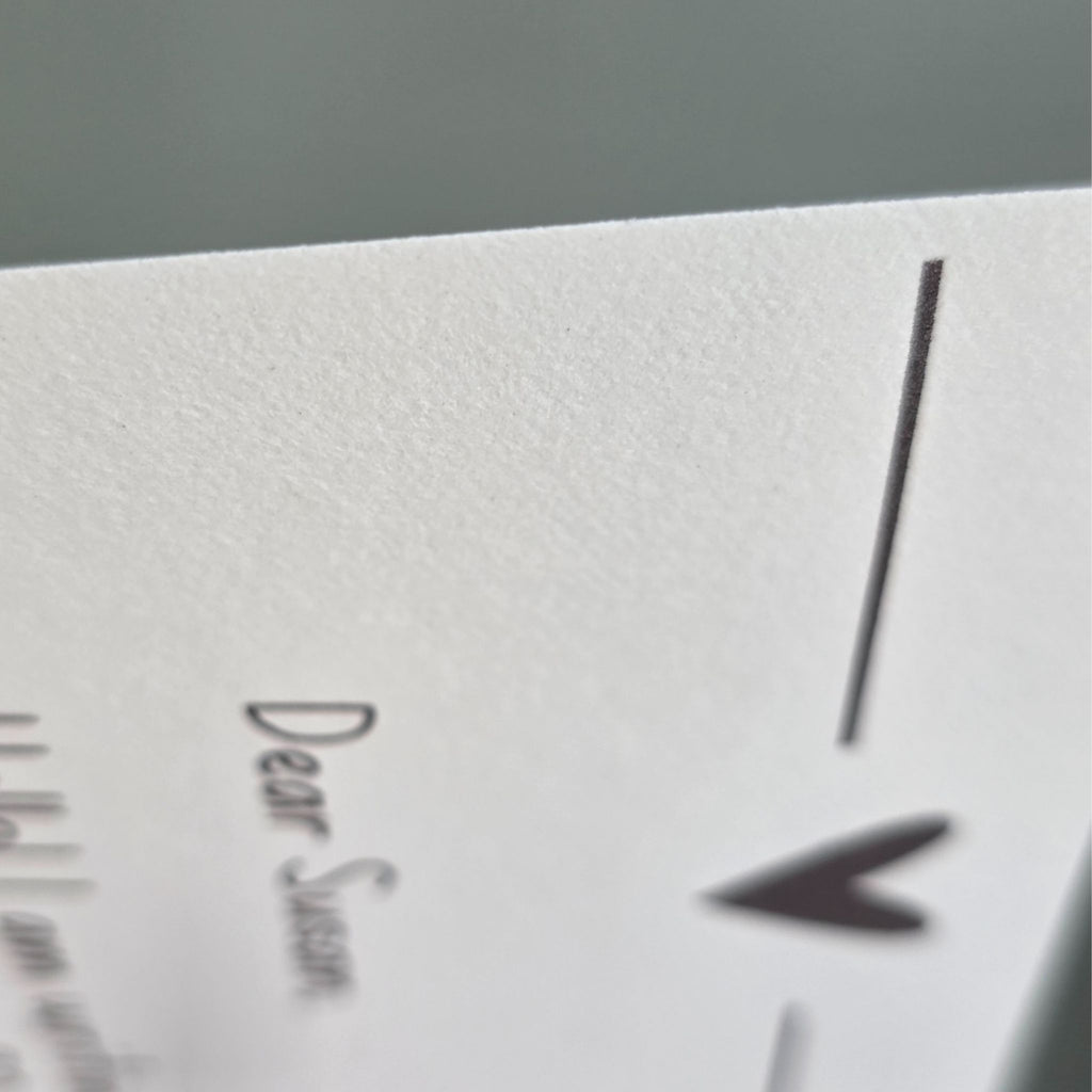 A side-profile macro shot of a single sheet of 24lb ivory paper, showing its substantial thickness and high-quality bond weight.